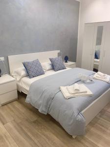 1 dormitorio con 1 cama grande y toallas. en Maryam23 en Siracusa