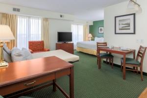 Habitación de hotel con cama y sala de estar. en Residence Inn by Marriott Oklahoma City South, en Oklahoma City