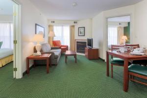 Habitación de hotel con cama y sala de estar. en Residence Inn by Marriott Oklahoma City South en Oklahoma City