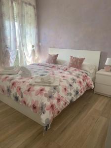 1 dormitorio con 1 cama con colcha de flores en Maryam23 en Siracusa