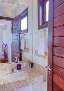 a bathroom with a sink and a mirror at Porto Serra Mar Flats Praia de Sibaúma- Pipa in Tibau do Sul