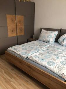 1 cama con marco de madera y almohadas en Haus Lisa 