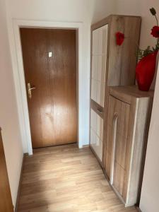 pasillo con puerta marrón y suelo de madera en Haus Lisa 