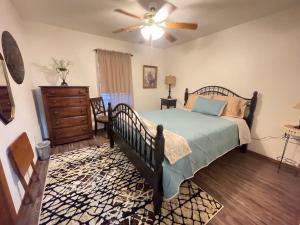 um quarto com uma cama e uma ventoinha de tecto em Cozy house centrally located close to everything in NWA em Springdale