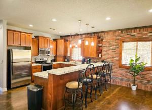 a kitchen with wooden cabinets and a brick wall at Beaver Lake Hideaway in Lowell