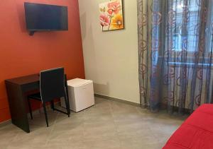 Oasi del Turista في باليرمو: غرفة بها مكتب وتلفزيون وكرسي