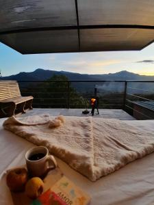 a table with a blanket and a fire on a balcony at Mamaterra Glamping in Macanal