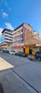 een gebouw met auto's geparkeerd aan de kant van een straat bij huascaran guest house 2 estrellas in Huaraz