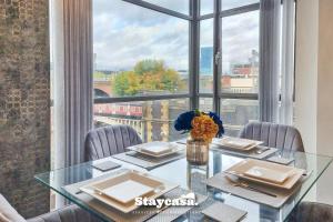 comedor con mesa de cristal y ventana grande en Luxury 2bdr Flat With Canal View & Free Parking en Mánchester