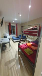 ラ・クールヌーヴにあるHotel le Privilegeの二段ベッド3台とデスクが備わる客室です。