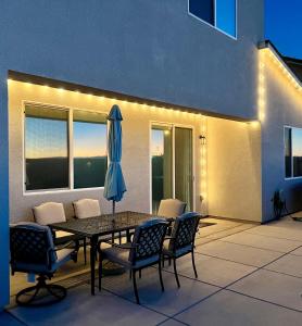 a patio with a table and chairs and an umbrella at Modern Ripon Home - Whole House with Garage in Ripon