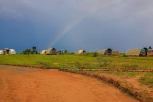een regenboog in een veld met een groep koepels bij Little Amanya Camp in Amboseli