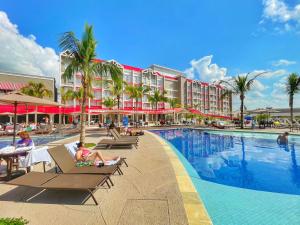 a resort swimming pool with people sitting in chairs next to a resort at São Pedro Thermas Resort in São Pedro