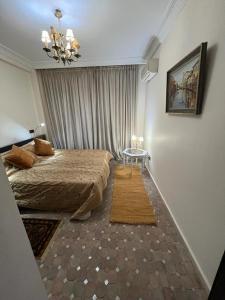 a bedroom with a large bed and a table at Luxury apartment 3 in the heart of Gueliz, Wifi, Pool in Marrakech