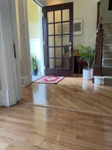 Point Breeze Guest House في بيتسبرغ: غرفة معيشة مع أرضية خشبية وباب