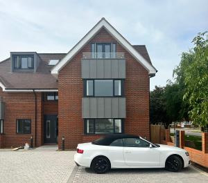 a white car parked in front of a brick house at The Penthouse Double Bedroom Free Parking in Epsom