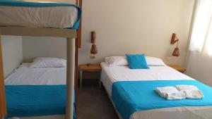 皮烏拉的住宿－Casasol_mancora，一间卧室配有两张双层床和毛巾