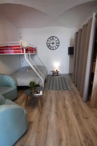 モン・ドファンにあるLe trio des alpesの二段ベッド、テーブル、時計が備わる客室です。