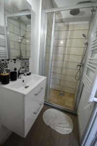 y baño con lavabo blanco y ducha. en Le trio des alpes en Mont-Dauphin