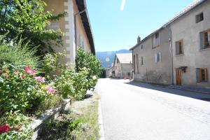 an empty street in a town with buildings and flowers at Le trio des alpes in Mont-Dauphin