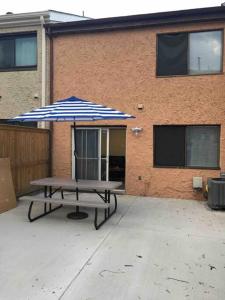 a picnic table with an umbrella in front of a building at Townhouse, 2 bdrm, 2.5 bthrm, 2 qn bds/2 levls in Greenbelt