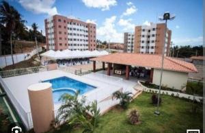 a large swimming pool in front of some buildings at Apartamento confortável e sofisticado em Aracaju in Aracaju