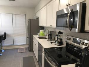 a kitchen with white cabinets and a black stove top oven at Entire Twnhouse 2bdrms 3Bthrm 2Qbeds 2Levls Fncd Bkyard in Greenbelt