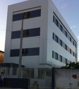 un bâtiment blanc avec une personne debout devant lui dans l'établissement Temporada CG - Apartamento no Alto Branco, à Campina Grande