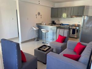 a living room with a couch and red pillows at Plataview Apartahotel 3B in Monte Plata