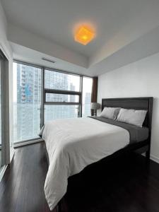a bedroom with a large bed and a large window at Home Away From Home in Toronto