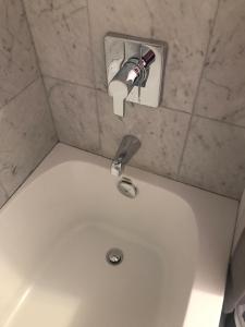 a white bath tub with a faucet in a bathroom at Home Away From Home in Toronto