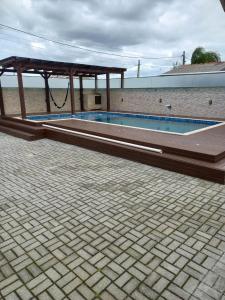 a swimming pool with a pavilion next to a building at Apartamento completo 1 quarto in Palhoça