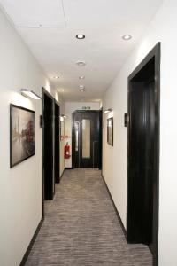 a corridor of a hallway with black doors and carpet at Great St Helen Hotel in London