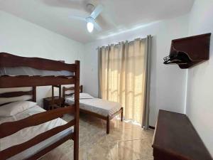 1 Schlafzimmer mit 2 Etagenbetten und einem Fenster in der Unterkunft Apto 50m da areia com wifi in Cabo Frio
