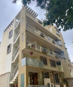 a tall building with balconies on the side of it at Luxury Queen Bed Suite 6km to Palace with Farm Land and Hill View in Mysore