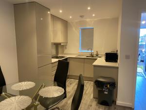 une cuisine avec une table et des chaises en verre et un évier dans l'établissement STAN LUXURY HOME, à Manchester