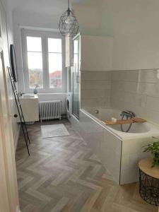 uma casa de banho branca com uma banheira e um lavatório em Grand appartement charmant à 10 min de Lille em Tourcoing