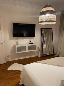 a bedroom with a flat screen tv on the wall at Grand appartement charmant à 10 min de Lille in Tourcoing