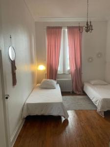 a bedroom with two beds and a window at Grand appartement charmant à 10 min de Lille in Tourcoing