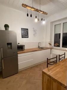 a kitchen with a refrigerator and a counter top at Grand appartement entier en hyper centre a 10 minutes de lille, métro a 50m et la gare de Tourcoing et à 900m et parking a proximité in Tourcoing
