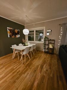 特羅姆瑟的住宿－Aurora apartment in Kvaloya Tromso，一间配备有白色桌椅的用餐室