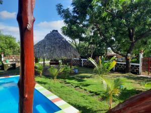 ein Resort mit einem Pool und einer Strohhütte in der Unterkunft Sea la vie casita in Las Peñitas
