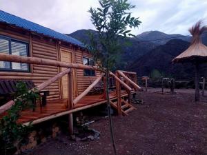 una cabaña de madera con un árbol delante en Rincón Trasandino en Potrerillos