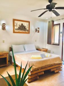 a bedroom with a bed with a ceiling fan at Thalatta Resort in Zamboanguita