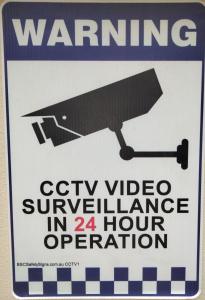 un cartel en una pared que advierte la videovigilancia en hora en Single Room in Wollongong near Uni en Keiraville