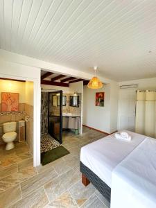 1 dormitorio con 1 cama y baño en Villa Sweet Caraïbes, vue mer, jacuzzi, en Les Trois-Îlets