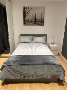 1 cama en un dormitorio con una foto en la pared en Self-contained en-suite room in Wembley en Londres