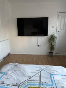 um quarto com uma televisão de ecrã plano na parede em Self-contained en-suite room in Wembley em Londres