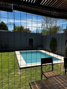 a view of a swimming pool through a fence at Chana's House in Chascomús