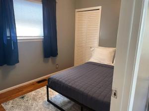 a small bed in a room with a window at Modern River Retreat near airport, hospitals, businesses 